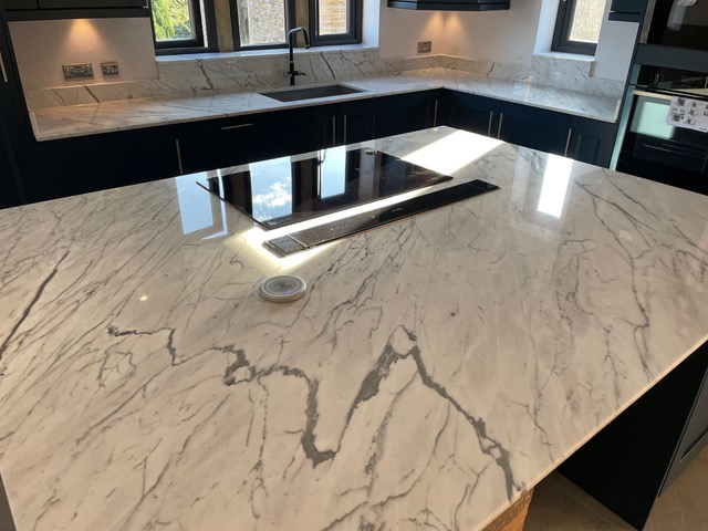 Marble effect island bar showing veins in white marble. Carrera White Island bar with hob cut out and downdraft cut out fitted in Flockton Wakefield