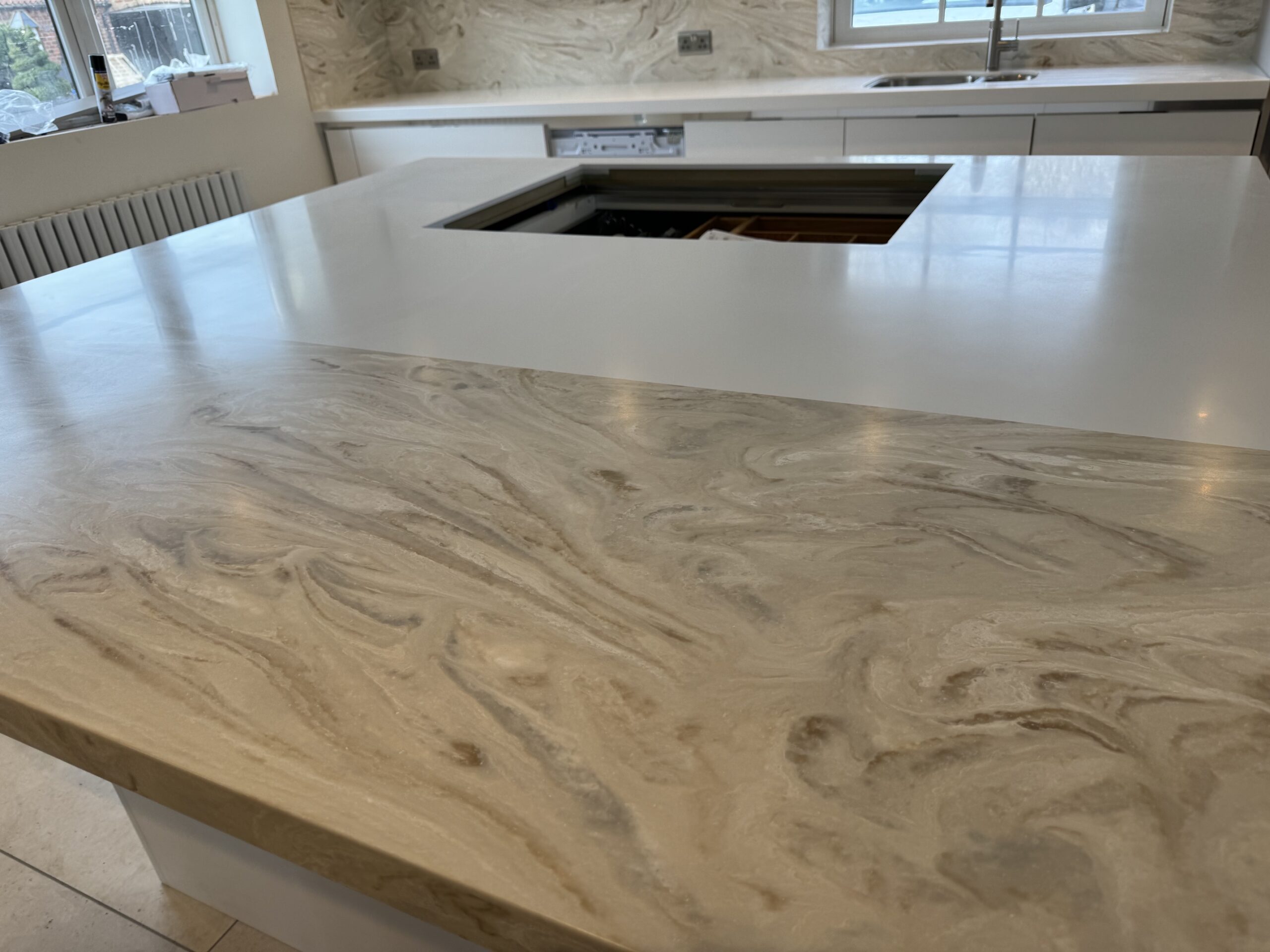 Corian island worktop with contrasting white and golden-brown and green patterned breakfast bar sections in Morley, Leeds.