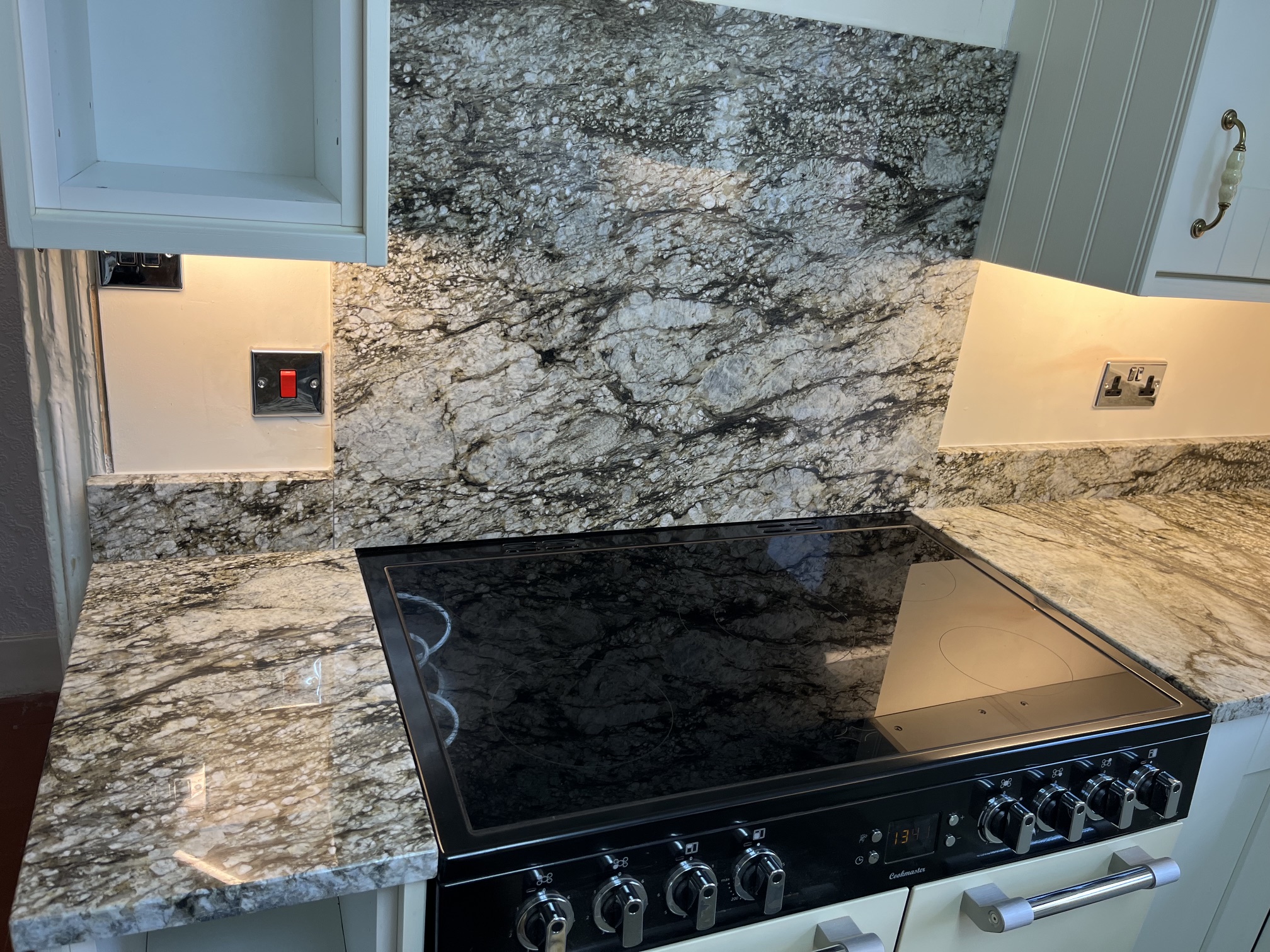 Giallo Antique granite worktops with a wide matching splashback behind a range cooker in Leeds.