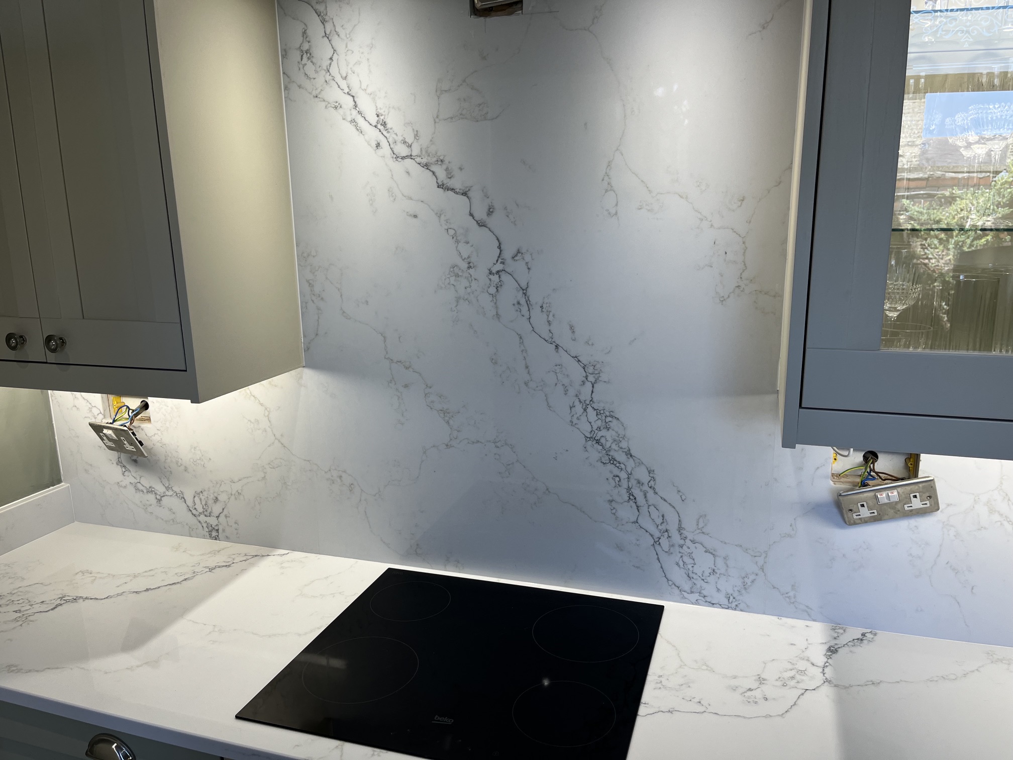 Carrera White quartz worktop with grey veining and matching full-height hob splashback in Halifax.
