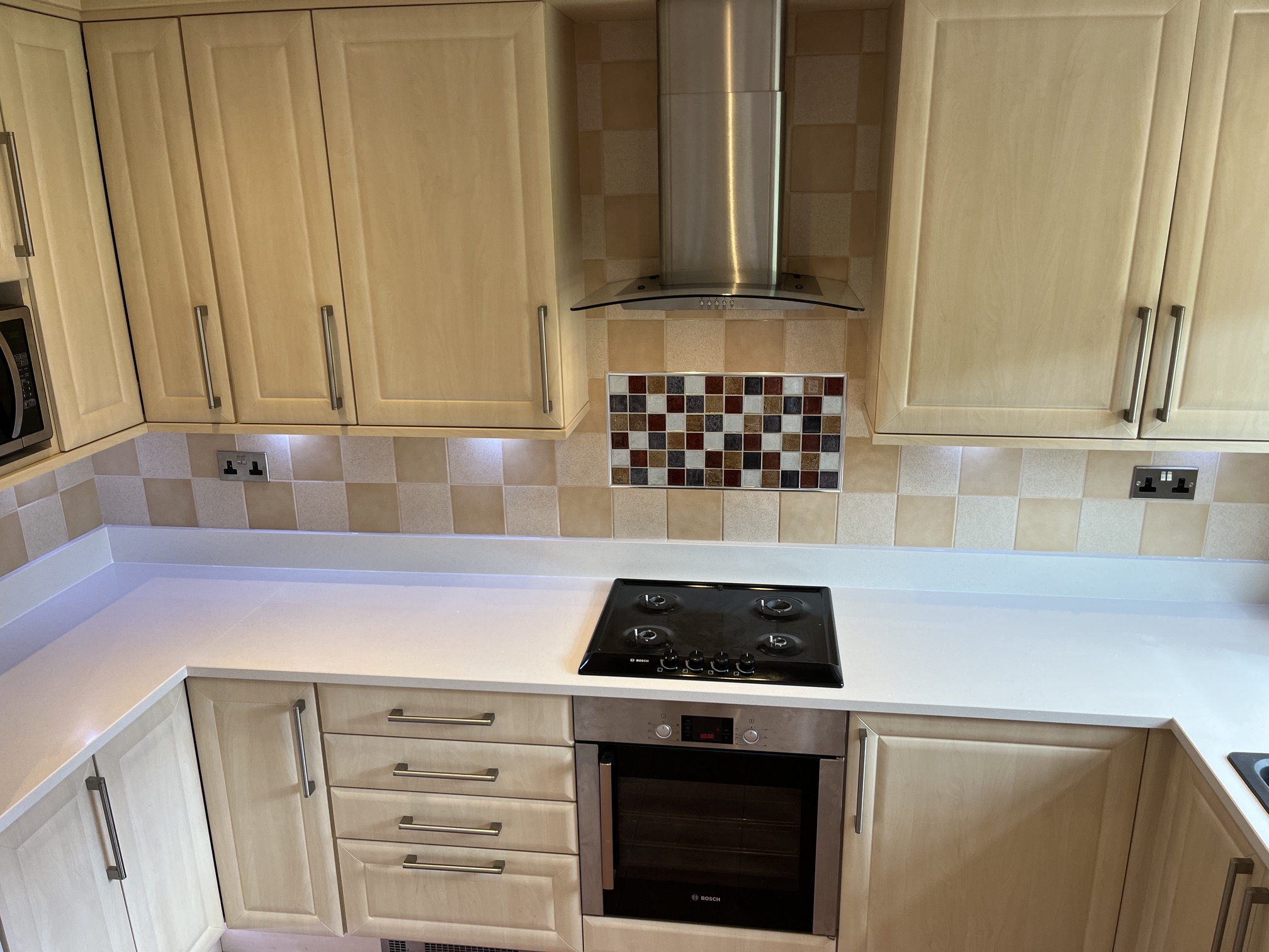 White quartz worktops with matching upstands beneath existing tiles in Barnsley