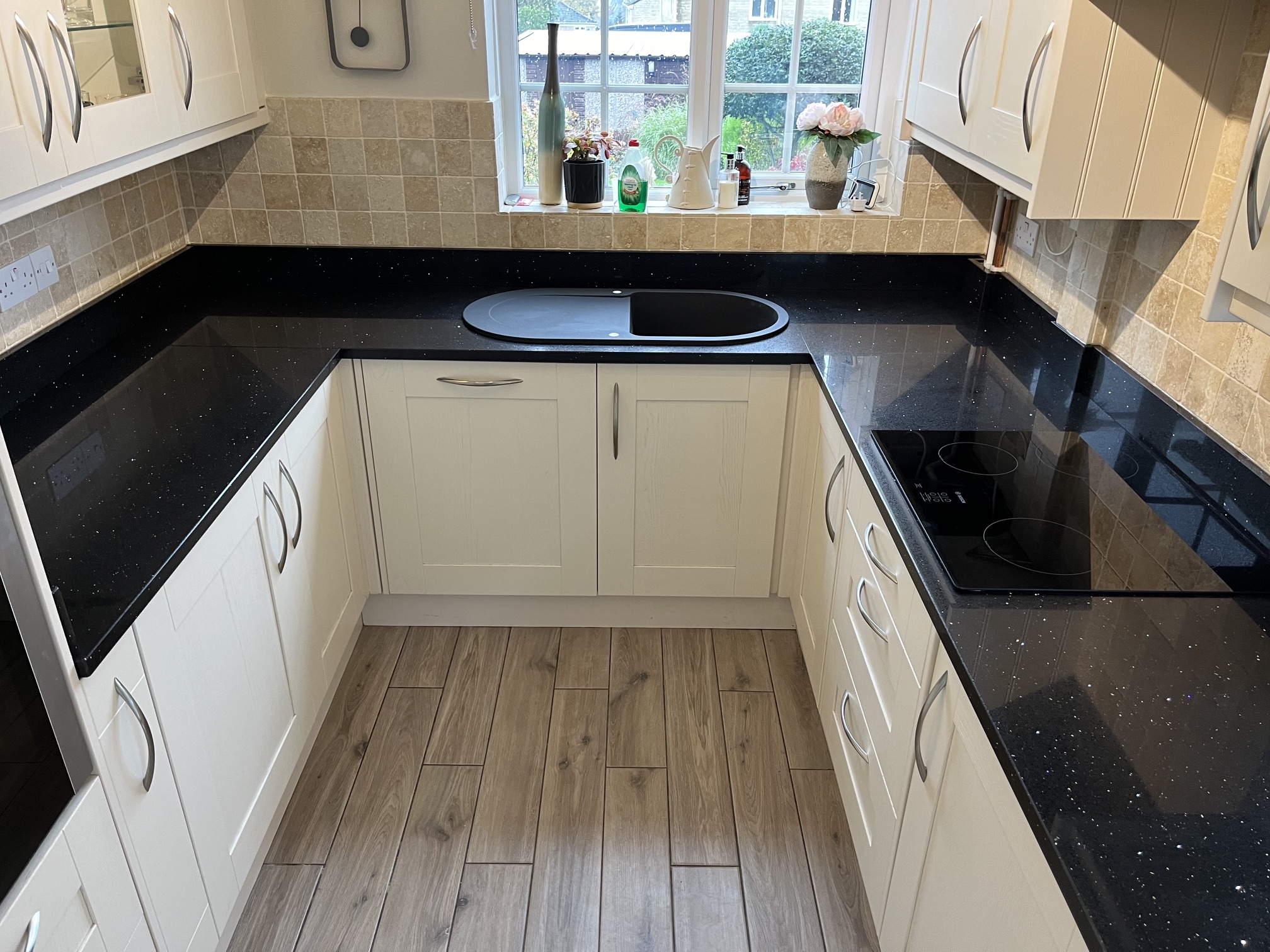 Black mirrored quartz worktops with matching upstands meeting the tile grout line in Huddersfield