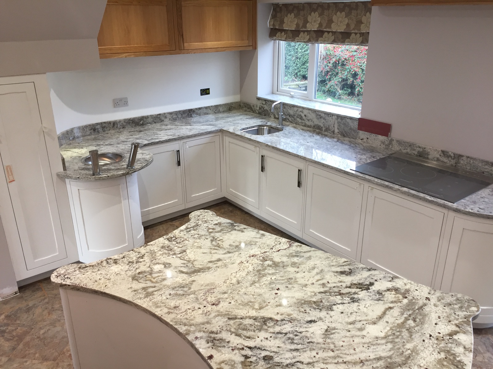 Bianco Romano granite worktops and curved island in a Huddersfield kitchen, with matching upstands