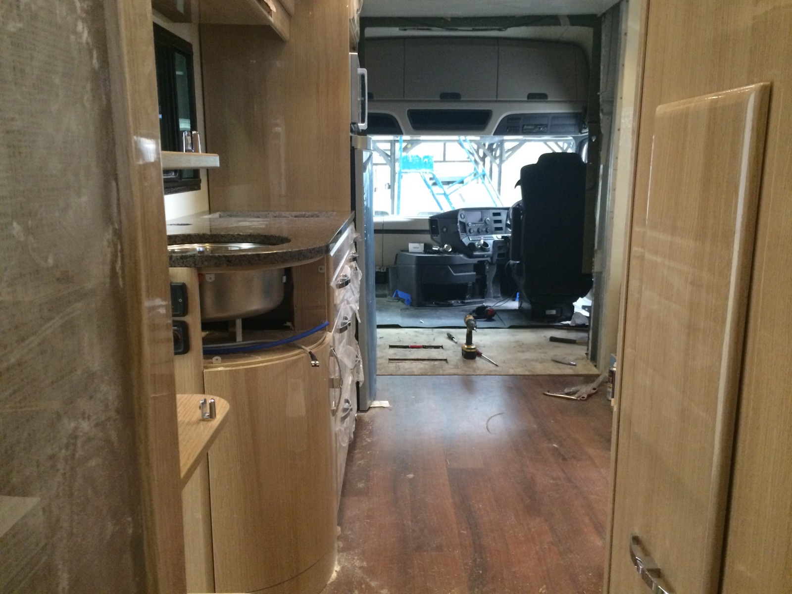 Blue Eye natural granite countertop with a curved edge and round stainless steel sink inside a luxury motorhome during fitting in Meltham.